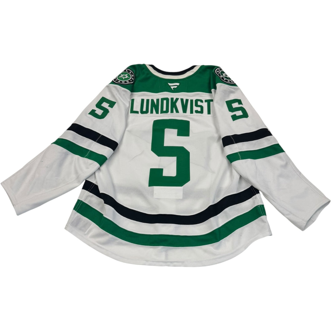 Game worn Dallas Stars away jersey with 'Lundkvist' and number '5'. jersey on a white background