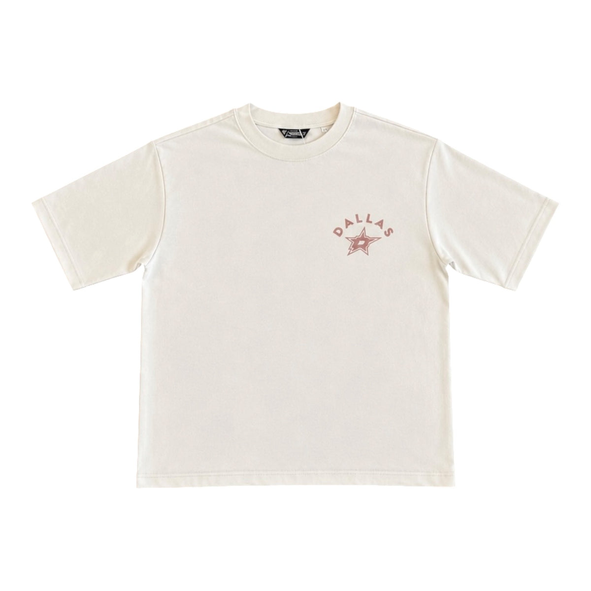 An off-white short-sleeve crewneck t-shirt with a tonal graphic on the left chest featuring the text 'DALLAS' and a star, displayed on a clean white background.